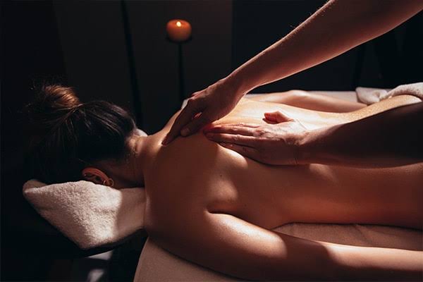 Sessão de massagem de relaxamento num ambiente calmo, com luz de vela